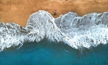 Anteni, üst aşağı: tanınmayan sörfçü egzotik kumlu plaj boyunca güneşli yaz gününde yürüyüş. Okyanus dalgaları sıçramasına seyir surfboard holding yalnız adam. Sıçramasına okyanus dalgalarının kumsalına ulaşmak