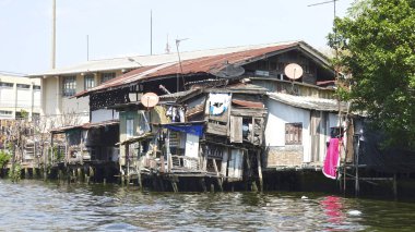 Binalar varoşlarda yoksul kesiminde çamurlu Nehri yakınında çürüyen kasvetli atış. Karşı karşıya kaldığı yoksulluğu yok ev geçmiş çalışan karanlık nehir suyu. Kirli kanalınkıyısında ahşap kulübe yok