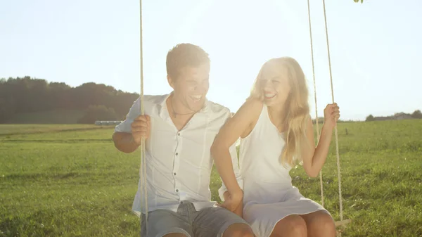 Lentes Flare Portrait Pareja Alegre Riéndose Cita Mientras Sienta Columpio — Foto de Stock