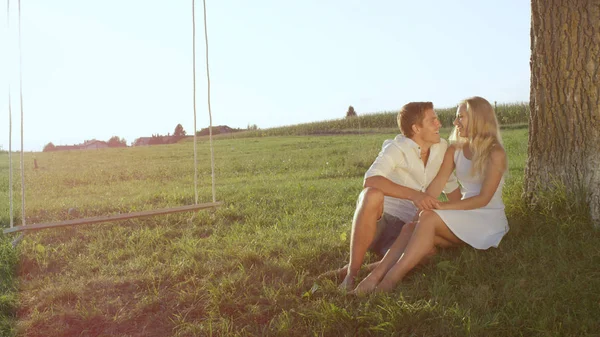 Lense Flare Romantic Young Couple Sitting Big Tree Talking Each — Stock Photo, Image