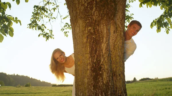 Close Portrait Smiling Couple Peeking Tree Summer Evening Sunrays Shining — Stock Photo, Image