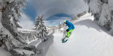 Aşırı freeride snowboard güneşli kışın karlı dağ yokuş aşağı oyma. Genç snowboard taze kar kar karlı dağlarda güneşli kış tatile adam. Güneşli kış sporları
