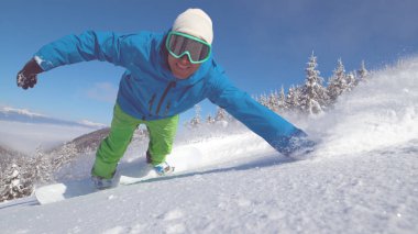 Kadar yakın, portre: Neşeli erkek snowboard onun aşırı kapalı pist sürüş sırasında kar elini sürükler. Sıcak kış güneşin tadını aktif erkek gülümseyen snowboard yaparken ışınları.
