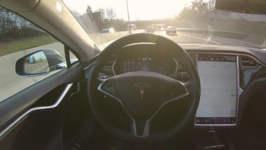 Tesla özerk araba, Mart 2018: Lens Flare: özerk Tesla araç sürücüleri kendisi kalabalık güneşli otoyol. Yeni nesil araba güneşli otoyol sabah sırasında gider saat şehirde acele..