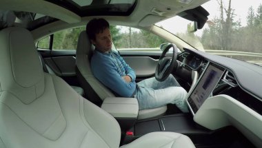 Tesla özerk, Şubat 2017: özerk bir elektrikli Tesla araba kendi kendine sürüş direksiyon direksiyonuna uyuyan erkek pilotu. Adam kırsal yol boyunca sürüş sırasında derin uykuya daldı