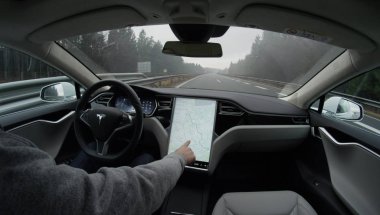 TESLA AUTONOMOUS CAR - FEBRUARY 4, 2017: Tesla autopilot self-driving in severe weather condition with no human intervention. Driver browsing the internet using touchscreen in futuristic autonomous car clipart