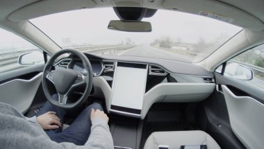 Self-driving Tesla Model S autopilot steering on highway. All electric autonomous car system navigating without the driver on motorway clipart