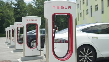 Tesla özerk araba - 10 Temmuz 2016: Beyaz ve enerji dolum Tesla özerk elektrikli arabalar siyah, süper hızlı şarj istasyonu üzerinde otopark ücretsizdir. Lüks araçlar pilin şarj edilmesi