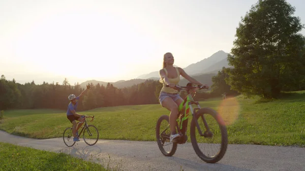 Obiektyw Pochodni Szczęśliwą Kobietą Bike Uśmiechy Jak Jeździ Przeszłości Walczy — Zdjęcie stockowe