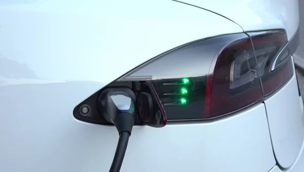 豪华特斯拉电动汽车的充电电池在增压站 昂贵的白色电动汽车充电 环保意识的交通工具插入加气 — 图库照片