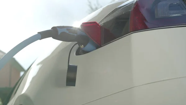 豪华特斯拉电动汽车的充电电池在家里院子里 昂贵的白色电动汽车充电 环保意识的交通工具插入加气 — 图库照片