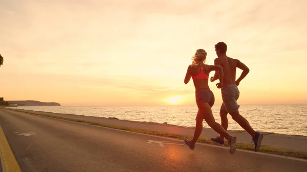 Kopierraum Unbekanntes Junges Paar Joggt Bei Sonnenuntergang Die Atemberaubende Meeresstraße Stockfoto