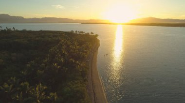 Anteni, Lens Flare: Pastoral akşam güneş ışınları aydınlatmak çarpıcı tropik ada kıyı şeridi. Yalnız küçük tekne demirlemiş nefes kesen yaz sabahı egzotik kumlu kıyı tarafından sakin Okyanusu.