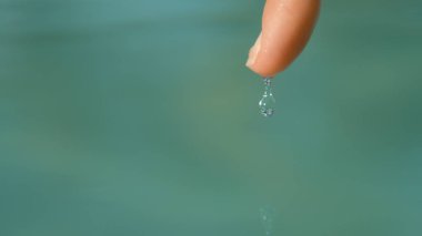 Makro, Dof: Serin bir kadeh tatil küçük su damlacığı tanınmaz halde kadının parmak ucu kapalı kaymasını yansıtılıyor. Parlak genç kızın parmak için zar zor tutarak havuzu su damla.