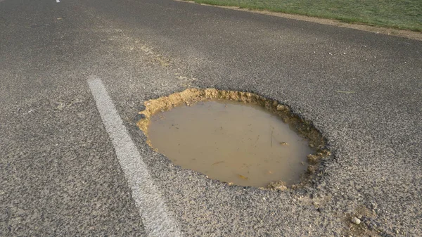 Zbliżenie Duży Pothole Środku Drogi Jest Wypełniona Mściwe Wody Ogromna — Zdjęcie stockowe