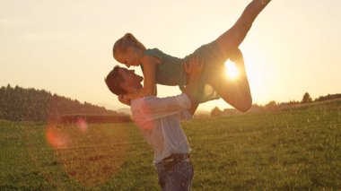 Kadar yakın, Lens Flare: Erkek dansçı üzerinde güzel gün batımını zahmetsizce neşeli sarışın kadın şekilde havaya kaldırdı. Çift dansları tutkuyla nefes kesen kırsal manzara içinde güneş doğarken çarpıcı.
