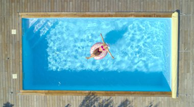 Anteni, üst aşağı: çarpıcı mavi havuz etrafında onun korku veren şişme halka üzerinde kürek çekmeye güzel sarışın beyaz kız. Komik bir floatie üzerinde bronzlaşma şık pembe bikini güneşte neşeli genç kadın.