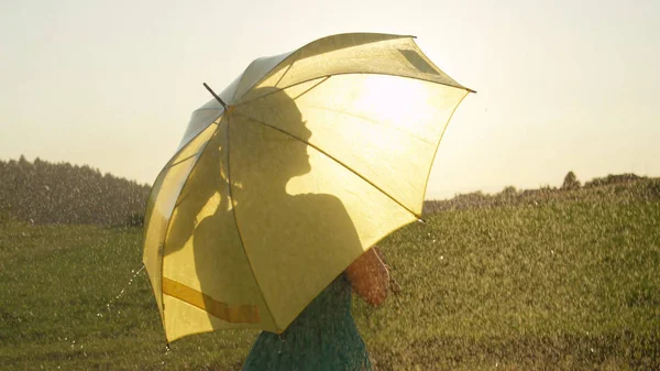 镜头耀斑 无法辨认的妇女享受多雨的夏季乡村的景色 在金色的乡村里 一个风景如画的日子里 一个不知名的女孩望着远处的壮观镜头 — 图库照片