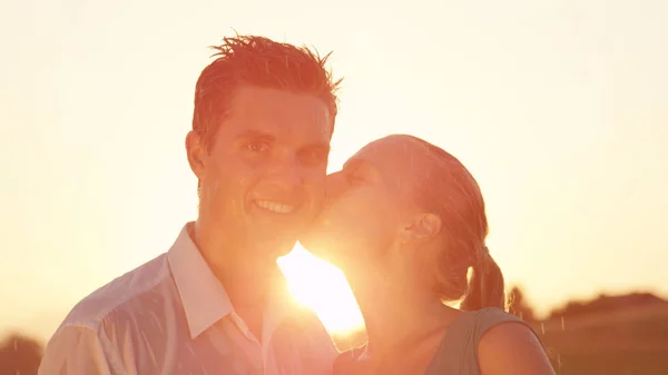 Retrait Lens Flare Mulher Loira Sorridente Beija Jovem Surpreso Bochecha — Fotografia de Stock