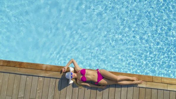 自上而下 年轻女子与惊人的体质晒黑在大游泳池的边缘晒黑 迷人的高加索游客在热带阳光下享受有趣的日光浴 在她惊人的暑假 — 图库照片