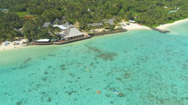 Hava: Turkuaz renkli okyanus ve turistler pitoresk Cook Adaları tatil zevk üzerinde uçan. Pasifik Okyanusu'nda yüzen ve kürek çeken insanlar sahil lerindeki otellerinin yakınında.