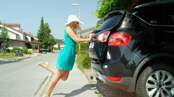 Девушка Высоких Каблуках Пытается Поместить Свой Багаж Багажник Внедорожника Припаркованного — стоковое фото