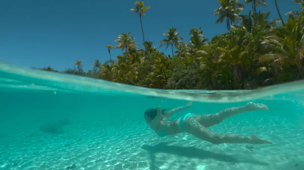 半水中 認識できない女性は 日当たりの良い太平洋で彼女の休暇中に白い砂の熱帯島のビーチに沿ってダイブします 若い女性旅行者が壮大なガラスの海の水で涼む — ストック写真