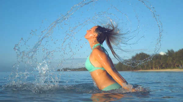 Игривая Белая Женщина Бирюзовом Бикини Брызгает Стеклянную Океанскую Воду Переворачивая — стоковое фото