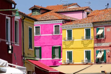 Burano, İtalya renkli evlerin beyaz çerçeveli pencereler ilerlerken göz muhteşem bir çekim. Güneşli bir yaz öğleden sonra Venedik kanallarıbakan çarpıcı evlerin pitoresk cepheleri boyunca yürüyüş.