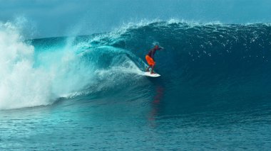 Yakın: Korkusuz genç pro surfboarder nefes kesen Tahiti'de bir camsı zümrüt okyanus dalgası geliyor. Muhteşem çekim aşırı sporcu doğru güneşli plajlar gürültüyle çarpmak bir büyük varil dalga sörf.