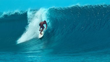 Yakın: Tahiti harika yaz tatil sırasında bir büyük kristal berraklığında tüp dalga sürme genç sporcu. Aşırı sporcu güneşli Fransız Polinezyası muhteşem varil dalga sörf. Eğlenceli su sporları.