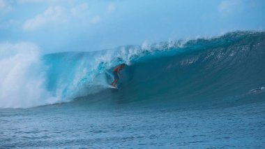 Korku veren aşırı Erkek sörfçü ile mükemmel bir gün güneşli Tahiti'de sörf için bir güzel zümrüt varil dalga gidiyor. Genç surfboarder muhteşem Fransız Polinezyası mükemmel dalgalarda yakalamak zevk.