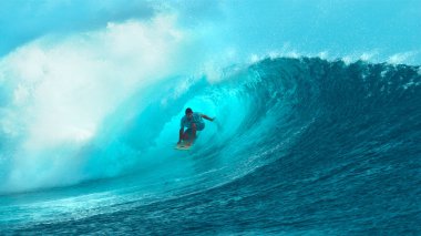 Yakın: Korkusuz genç surfboarder içinde muhteşem varil dalgası geliyor. Vahşi zümrüt dalgasının kıvrık ve güneşli Fransız Polinezyası eğleniyor pro Erkek sörfçü üzerine sıçramasına nefes kesen atış.