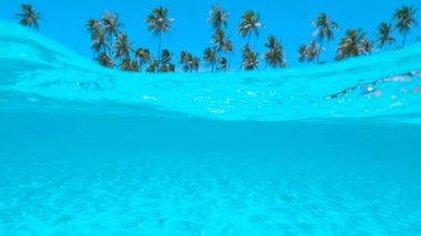 Yarım su altı, Dof: berrak okyanus dalgalarının Tayland çarpıcı kumlu kıyı yaklaşım. Tropik cennet Island beach filme kamera kapsayan zümrüt egzotik deniz nefes kesen görünümü.