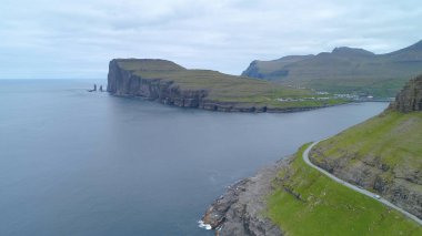 Hava: sakin okyanus ve muhteşem kayalıklarla ve yüksek çimenli dağlar altında gizleme küçük balıkçı köyü doğru uçan. Yeşil Faroe Adaları engebeli kıyı muhteşem çekim.