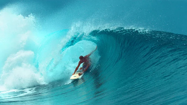 Yakın: Genç profesyonel surfboarder Fransız Polinezyası güneşli bir günde başka bir epik tüp dalga sürme tamamlanır. Eğleniyor ferahlatıcı zümrüt suda sörf için mükemmel bir gün sörfçü.