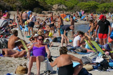 Corsica, Fransa - Eylül 2017: Kitleler, turistlere Akdeniz ünlü bir adanın kumlu bir plaj üzerinde güneşlenmek. Güneşli bir günde Corsica'deki / daki popüler kıyı tatil sayısız kişi akın.