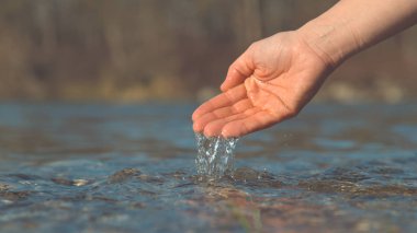 Kadar yakın, Dof: bilinmeyen nazik kadının elinden akan parlak kristal berraklığında nehir suyu. Tanınmayan oynak kız soğuk cam gibi Göl su bir avuç kadar güneşli bir sonbahar gününde kaşık toz.