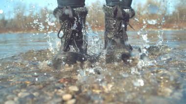 Stomping yakın kadar neşeli kız ayaklarının sığ göl ve onun etrafında sıçramasına cam gibi su. Oynak kadın onun Çizmeli sakin nehir etrafında atlama. Tanınmayan kadın sonbaharda zevk