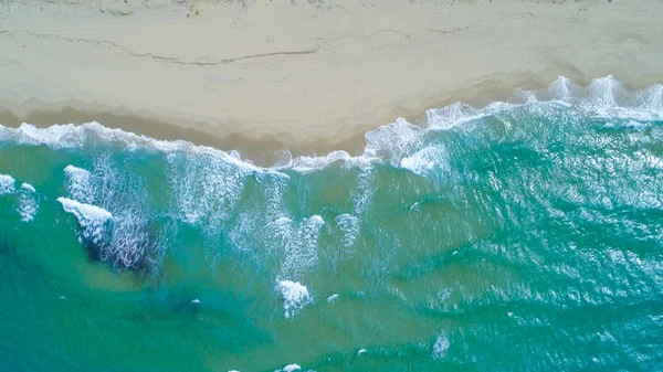 自上而下 飞越一个空旷的棕色沙滩和美丽的翡翠海浪 在炎热的夏天 在田园诗般的撒丁岛上拍摄到了偏远海岸的壮观镜头 风景如画的海岸线和大海 — 图库照片