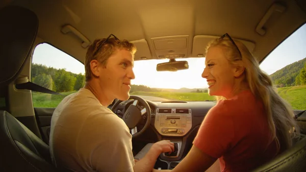クローズ アップ 幸せな女と男 牧歌的な夏の夜の美しい田園地帯を通って運転している間互いの目を見てします 風光明媚を楽しんでいる陽気なカップルは田舎道をクルーズします — ストック写真