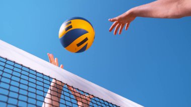 Kadar yakın, düşük açı: Voleybol oyuncunun puanı noktası tanınmaz kızın elleri üzerinde topu spiking tarafından eller. Plaj voleybolu bir güneşli yaz gününde tanınmaz halde genç atletik oynayanlar.