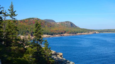 Hava: renkli orman içinde ve huzurlu mavi göl pitoresk Acadia Milli Parkı'nda doğru uçan. Sonbahar güneşli güzel engebeli kıyı. Doğal New Hampshire'da gözetleme yaprak.