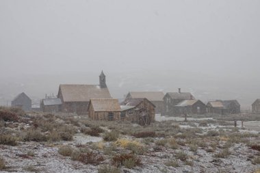 Soğuk kış hava Sierra Nevada bir terk edilmiş maden kasabası üzerinde toplar. Ismarlayarak soğuk kış ilk kar yağışı ayrışma pastoral ahşap hayalet kasaba. Güzel vahşi