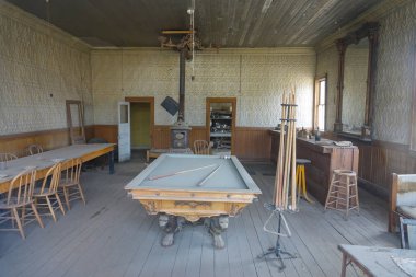 Serin kapalı görünümünü tozlu Bodie terk edilmiş maden kasaba çürüyen bar. Bilardo masası ve engebeli hava Californian vahşi doğada ayrışma bir salon. Vintage bir salon tozlu kalıntıları.