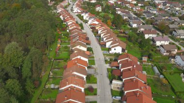 Hava: sakin banliyö komşuları'nda lider bir boş asfalt yol üzerinde uçan. Güneşli bir Sloven şehir banliyölerinde sayısız satır evlerin ısmarlayarak. Turuncu ve kırmızı çatılar.