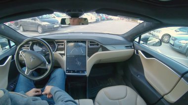 Tesla özerk araba, Mart 2018 - kadar yakın: ters meşgul bir otoparkta park ederken özerk bir Tesla arabaya Genç beyaz adam oturur. Kendini bir direksiyon araba harika yüksek teknoloji özelliği.