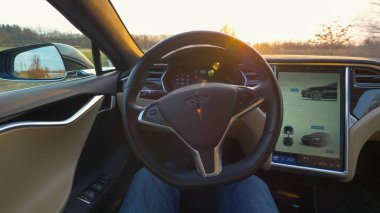 Özerk Tesla araba, 2018 Pov, Lens Flare Mart: kırsal güneşli bir akşamı araba araba gezinme kendi kendine oturan erkek sürücü. Altın güneş ışınları Parlatıcı bir Tesla kokpit içine 