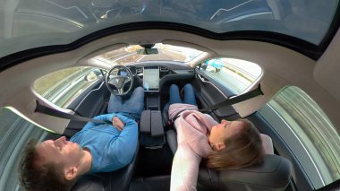 Tesla özerk araba, Mart 2018 - kadar yakın: Genç bir çift bir yüksek teknoloji bir otoyol aşağı araba kendi kendine seyir ederken uyur. Dikkatsiz kadın ve rahatlatıcı bir yolculuğa özerk Tesla içinde zevk adam