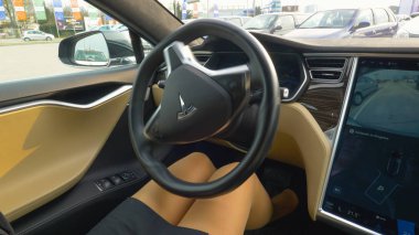 Özerk Araba, Mart 2018 - tanınmayan işkadını yakından yüksek teknoloji kendi kendine park Tesla arabada oturuyor. Otonom araç parkları ters direksiyon tutan genç kadın olmadan